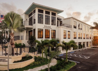 a large white building with palm trees in front of it