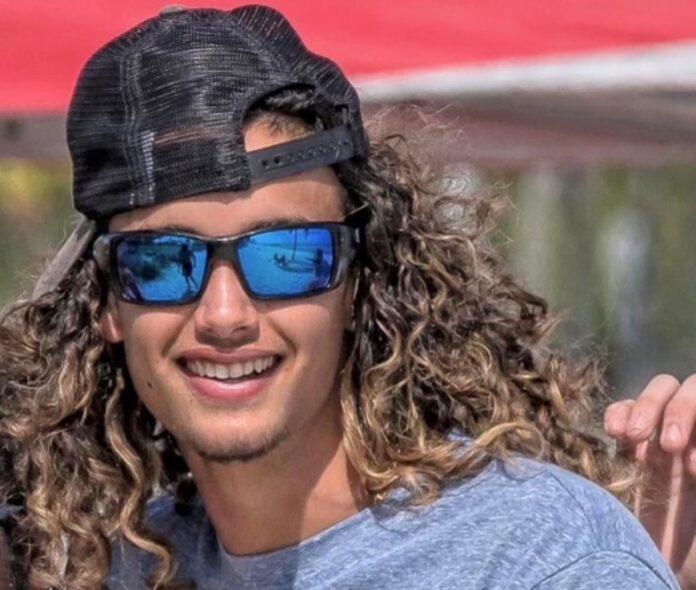 a man with long curly hair wearing a hat and sunglasses