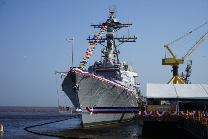 a large ship docked at a pier with a crane nearby