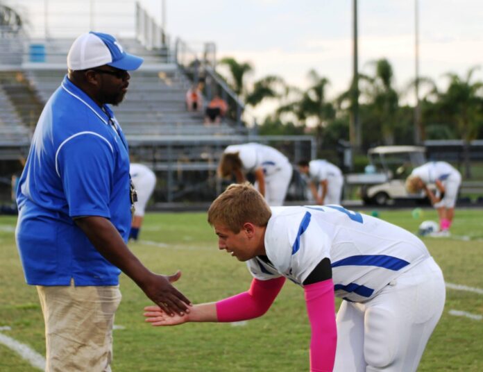 a man in a blue and white uniform is holding a child's hand