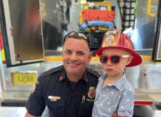 a man and a young boy in front of a fire truck