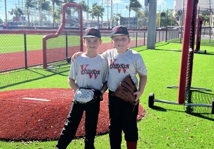 a couple of young men standing next to each other on a field