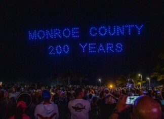 a crowd of people standing in front of a neon sign