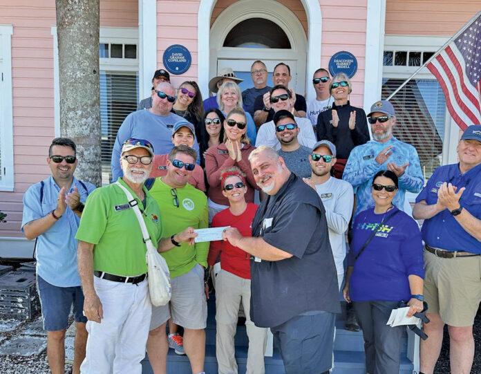 a group of people standing in front of a pink house