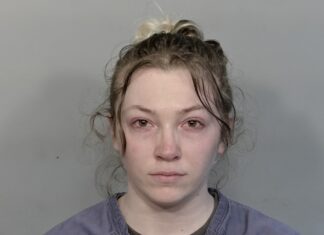 a mug shot of a woman with a messy bun