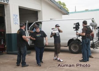 a group of men standing in front of a white van