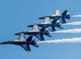 a group of fighter jets flying through a blue sky