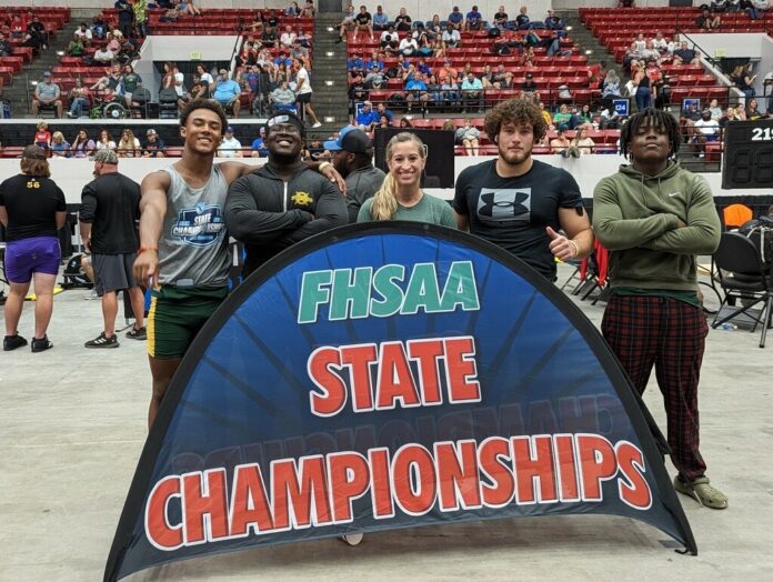 CSHS Weightlifting Large a group of people standing next to a sign
