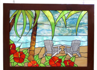 a stained glass window with two chairs on the beach