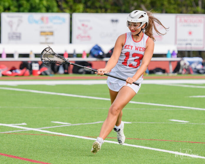 a female lacrosse player in action on the field