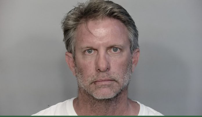 a mug shot of a man in a white shirt