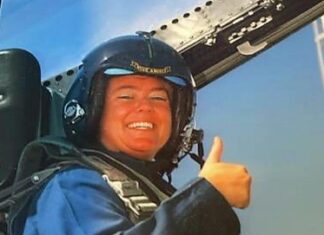 a man in a blue jacket holding a black object