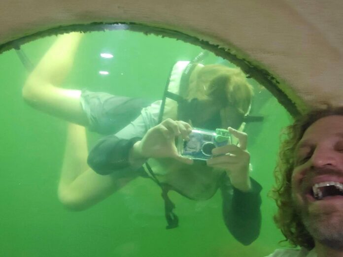 a man taking a picture of a woman underwater