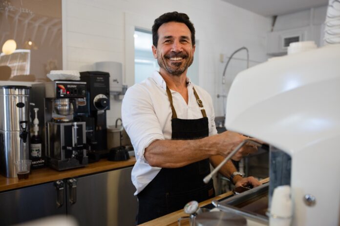 a man in an apron is making something in a blender