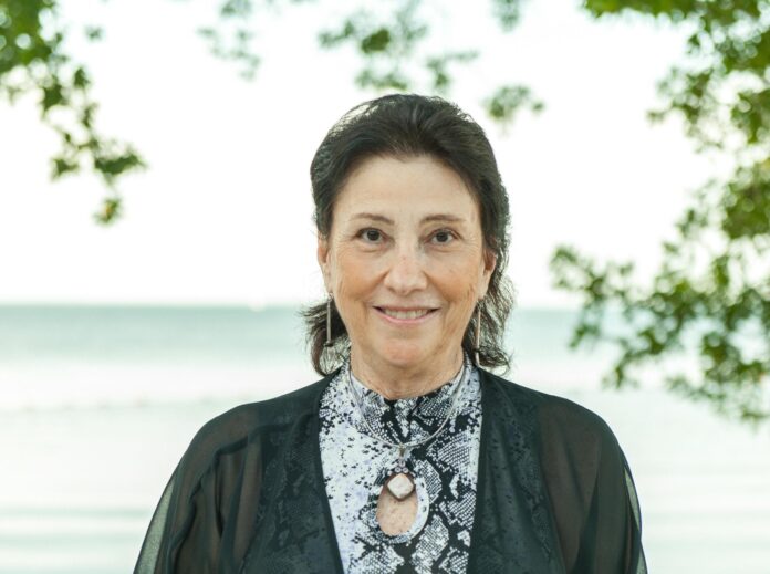 a woman standing in front of a body of water