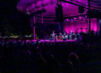 a stage with a band performing on it at night