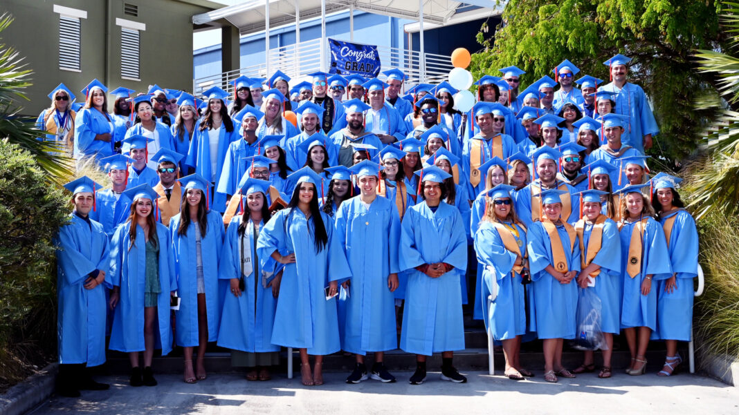 a group of people in blue graduation gowns posing for a picture