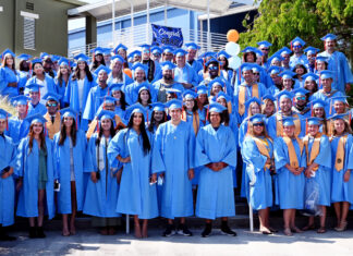 a group of people in blue graduation gowns posing for a picture