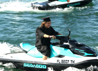a woman riding on the back of a blue and black jet ski