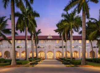 a large white building surrounded by palm trees