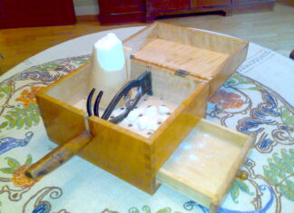 a wooden box with scissors in it on a table