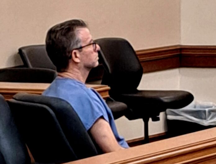 a man sitting in a chair in a courtroom