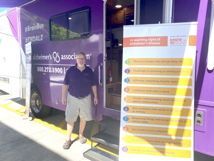 a man standing in front of a purple food truck