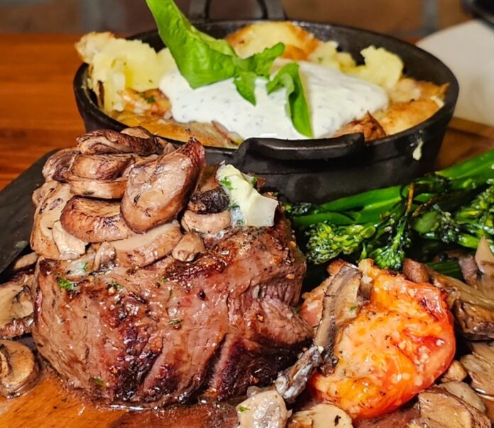 C&C steak 1 a wooden table topped with different types of food