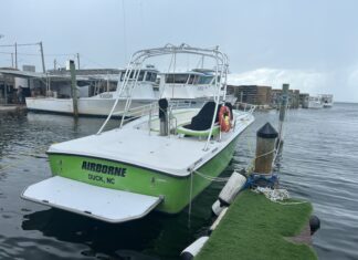 THIRD LAWSUIT FILED IN PARASAIL DEATH AS COMPANY RESUMES MARATHON OPERATIONS a green and white boat docked at a dock