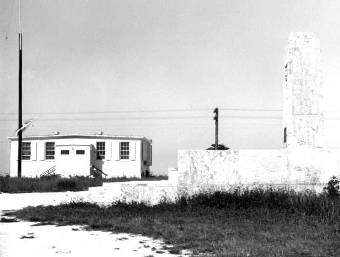 a black and white photo of a building and a fire hydrant