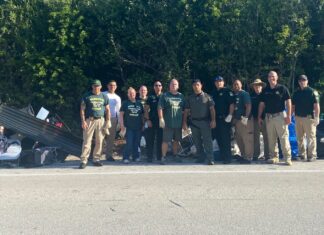 a group of people standing on the side of a road