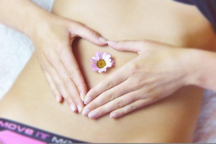 a woman holding a flower in her stomach
