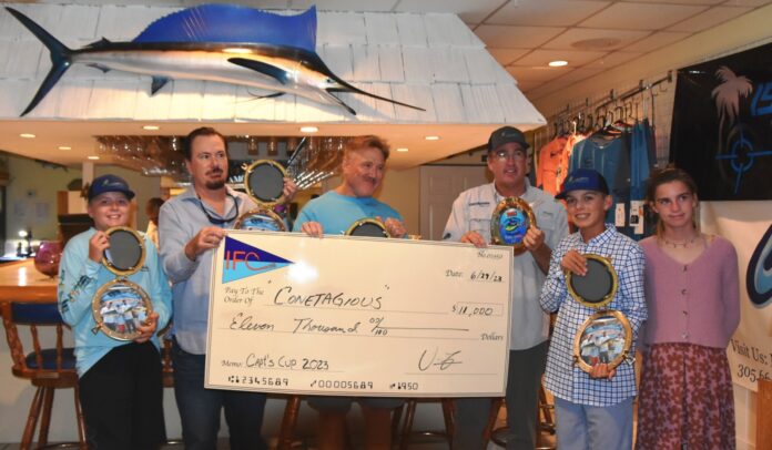 a group of people holding up a large check