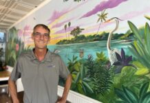 a man standing in front of a mural