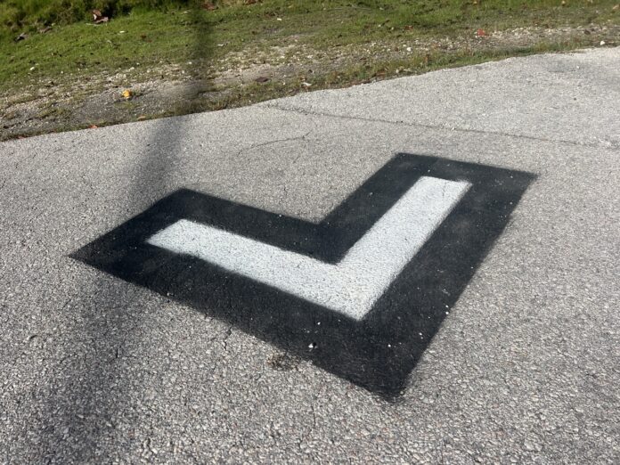 a black and white arrow painted on a road