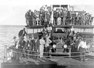 a large group of people standing on a boat