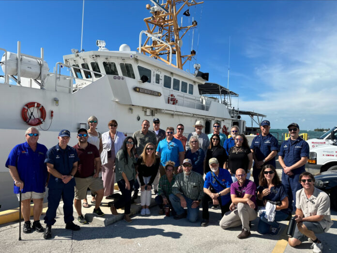 a group of people standing in front of a boat