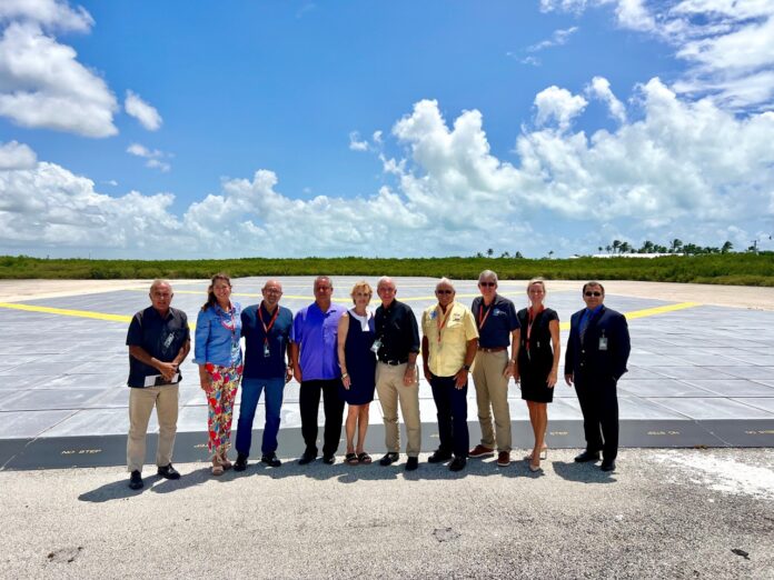 a group of people standing in front of an airport tarmac