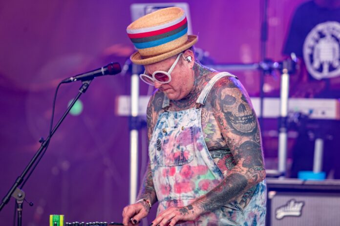a man with tattoos playing a keyboard on stage