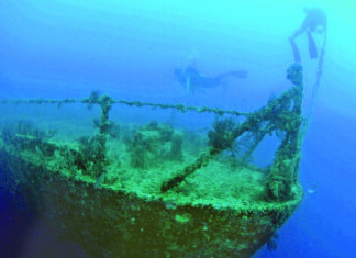 a ship in the water with a scuba diver nearby