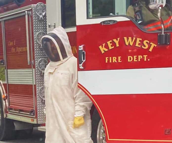 a man in a hazmat standing next to a fire truck