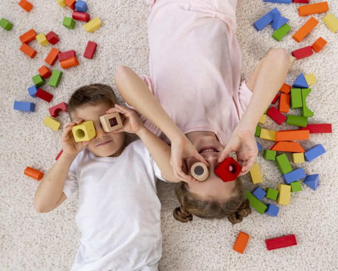 a couple of kids laying on top of a floor