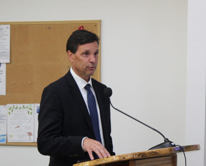 a man in a suit and tie standing at a podium