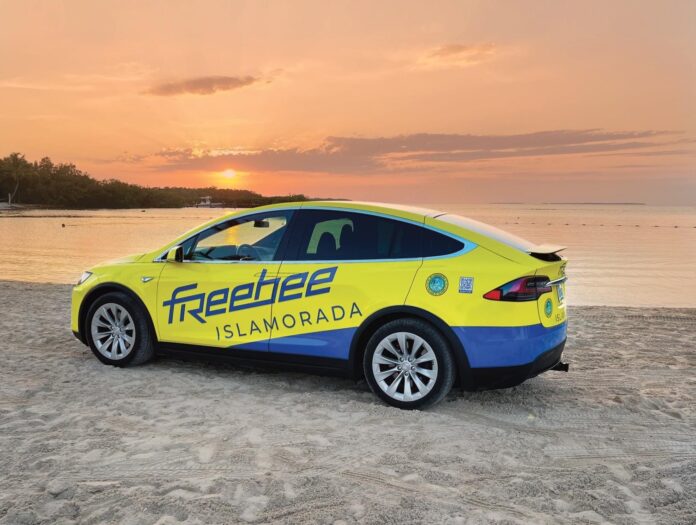 a yellow and blue car parked on the beach