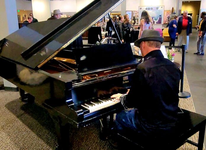 a man sitting at a piano in a lobby