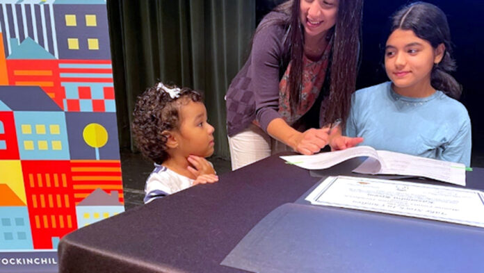 Take Stock PR 0831 a woman and two children sitting at a table