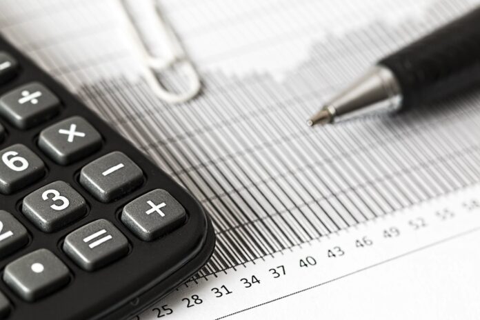 a calculator and a pen sitting on top of a sheet of paper