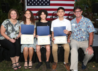a group of people standing next to each other holding diplomas