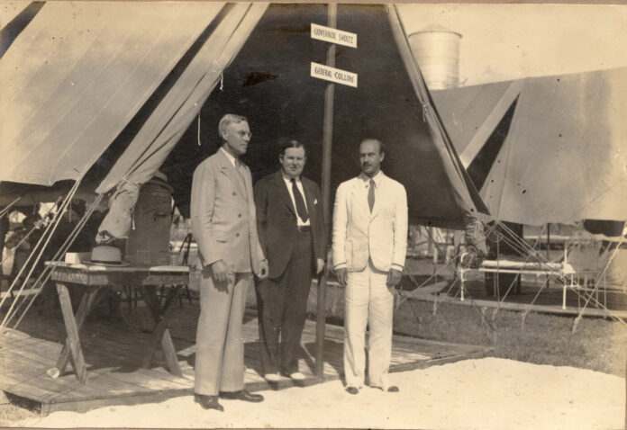 a group of men standing next to each other in front of a tent