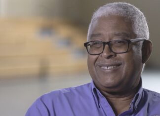 a man wearing glasses and a purple shirt